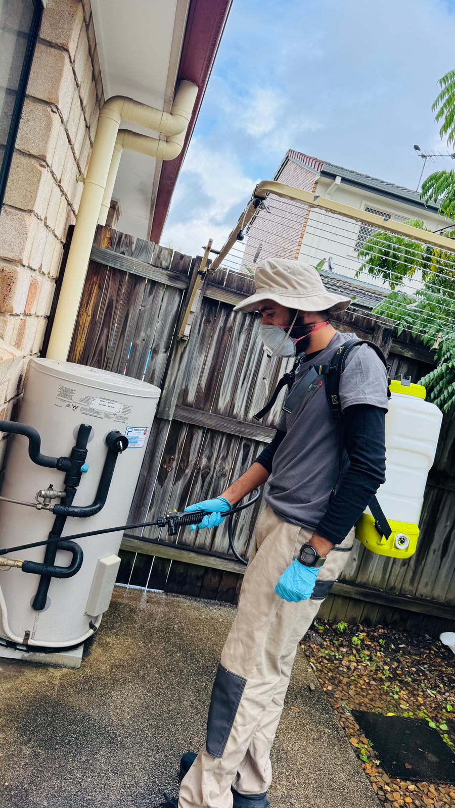 Pestigo technician treating external service area beside a home