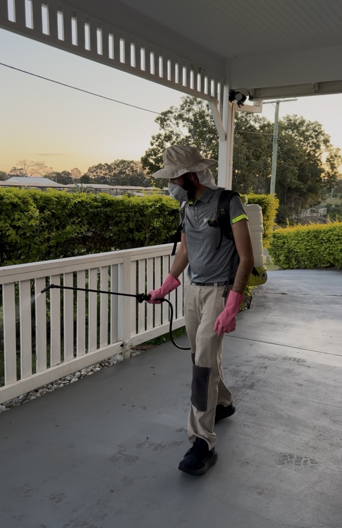 Pestigo technician applying an outdoor pest treatment at a home