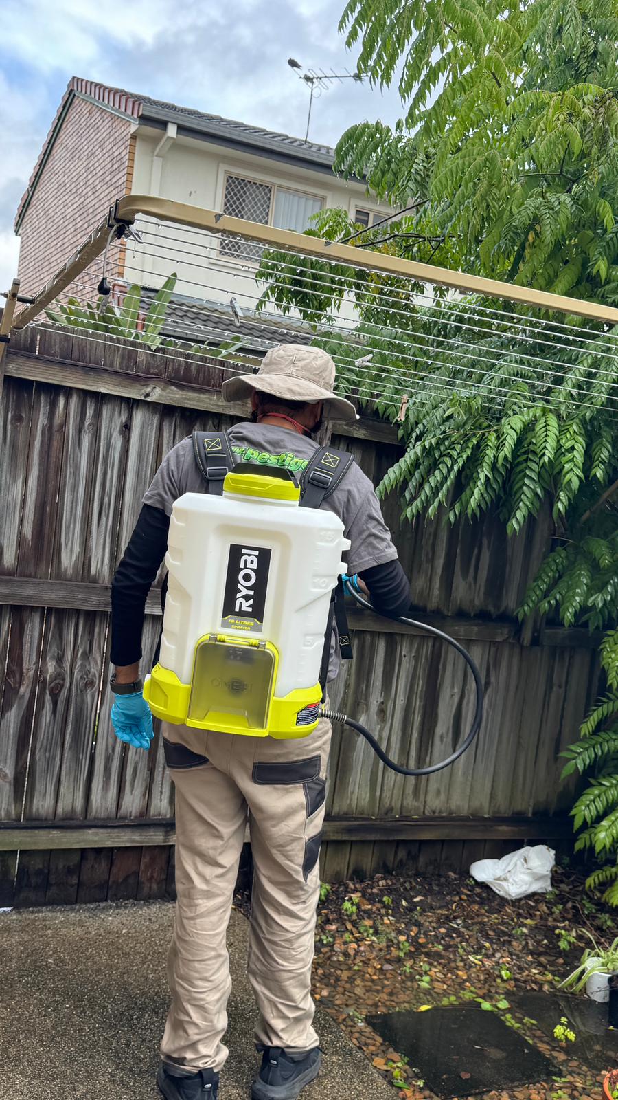 Pestigo technician carrying out outdoor perimeter pest control treatment